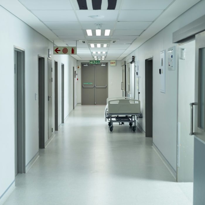 Moveable hospital bed in an empty hospital corridor, copy space